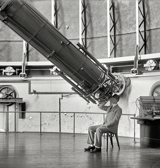 Retro foto van de wetenschapper die met de telescoop naar de lucht kijkt